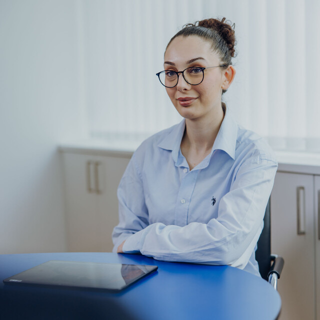 Ausbildung zum Steuerfachangstellten Eine Person sitzt am Tisch bei der ATG und lächelt