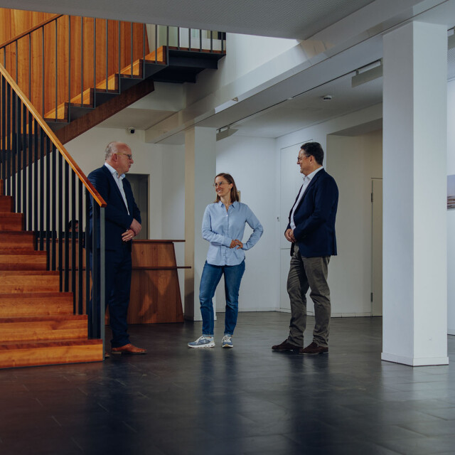 Unterhaltung im Eingansbereich Drei Personen stehen im Eingangsbereich der ATG und unterhalten sich