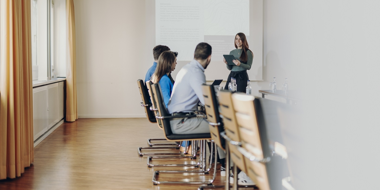 Steuerfachangestellte hält vor ihren Kollegen eine Präsentation